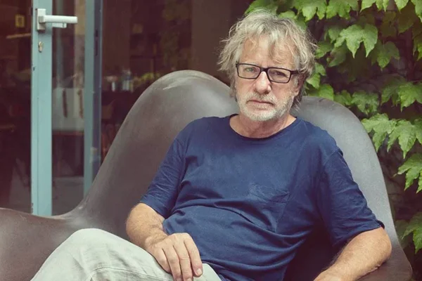 Foto colorida de Javier Mariscal usando blusa azul, óculos e calça - Metrópoles