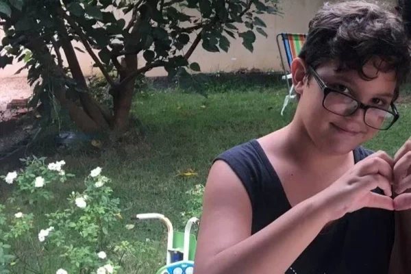 Imagem colorida de criança fazendo um coração com a mão; enteado teria sido morto pelo padrasto - Metrópoles
