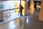 Momento em que o criminoso quebra a vidraça e entra no prédio