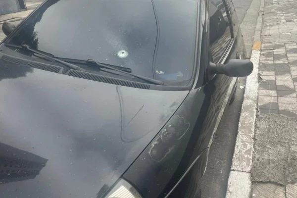 Foto colorida de carro com furo provocado por disparo de arma de fogo, após discussão entre vizinhos, em Suzano, na Grande São Paulo. Um homem acabou baleado - Metrópoles