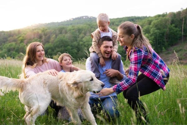 Família brincando ao ar livre com cachorro golden retriever