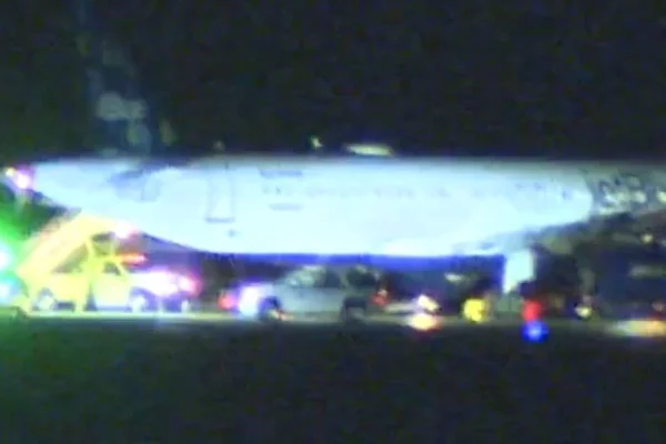 Imagem colorida de avião parado após passageiro abrir porta - Metrópoles