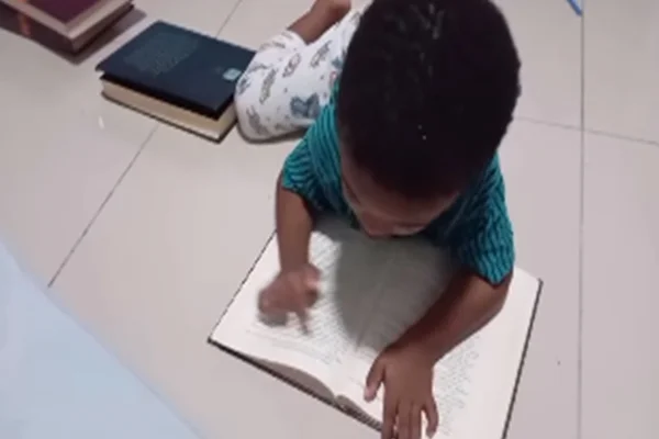 Imagem colorida do pequeno baiano lendo - Metrópoles