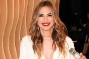 Luciana Gimenez posa de roupa branca, batom vermelho e sorrindo