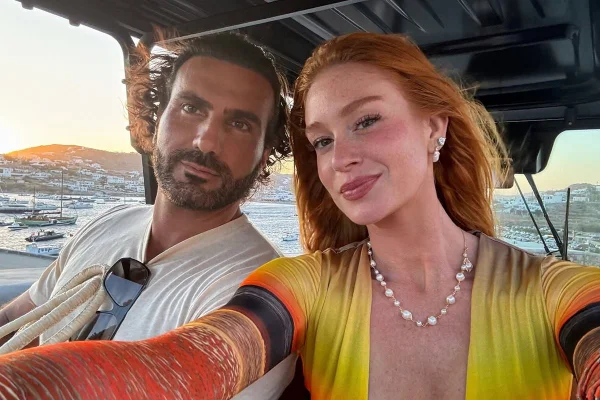 Foto colorida de homem e mulher fazendo selfie em barco - Metrópoles