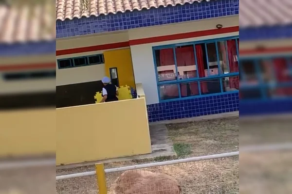 Imagem de uma creche, com paredes coloridas, e uma monitora vestindo azul e branco