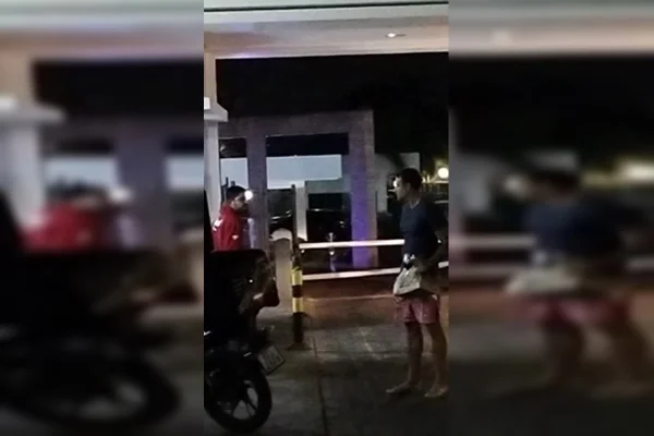 Imagem colorida de dois homens se olhando na frente de condomínio