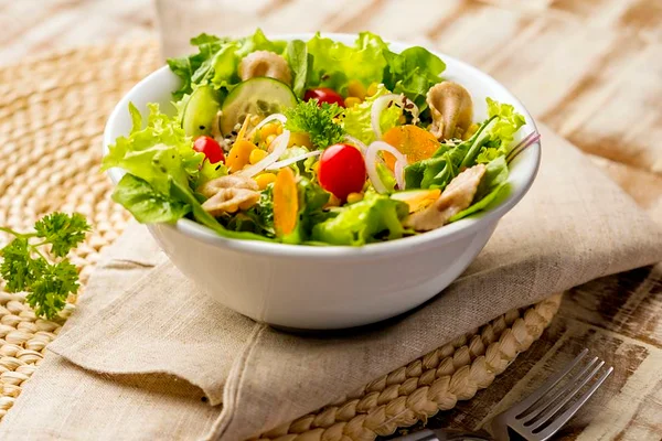 Foto colorida de um recipiente branco com salada dentro