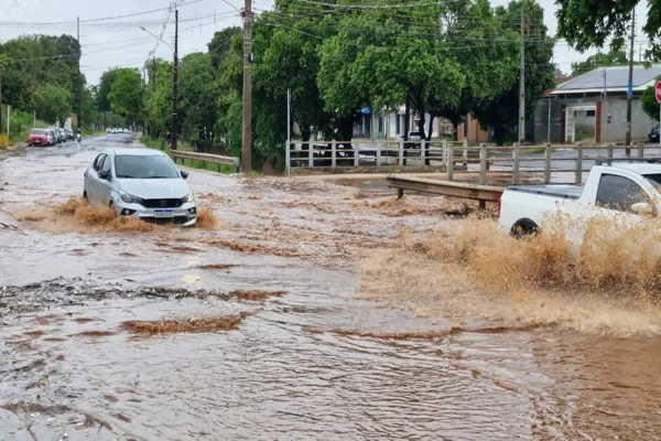 Imagem colorida, córrego transborda e transforma avenida em rio durante tempestade- Metrópoles