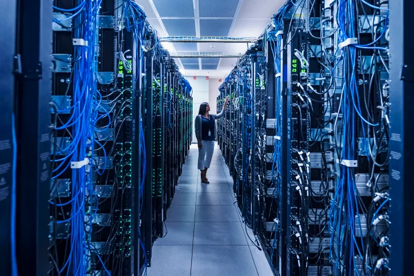 Mulher em pé no corredor da sala de servidores de um data center