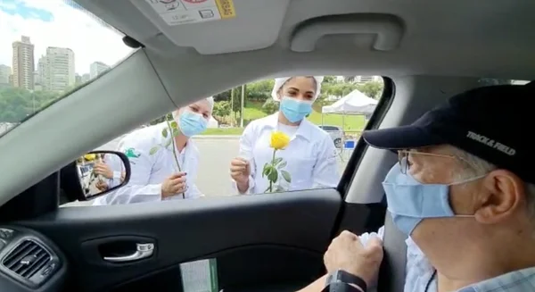 Idoso presenteia enfermeiras com flores antes de ser vacinado contra a Covid-19