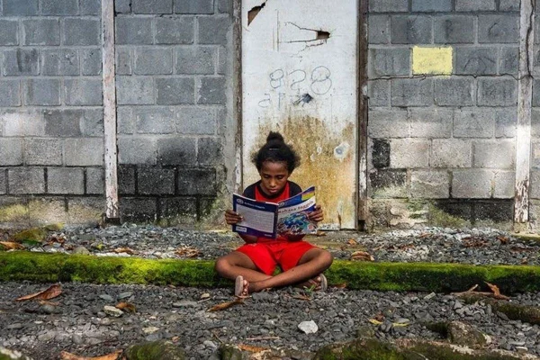 Menina lendo um livro em Papua, uma das províncias mais pobres da Indonésia IDH - Metrópoles
