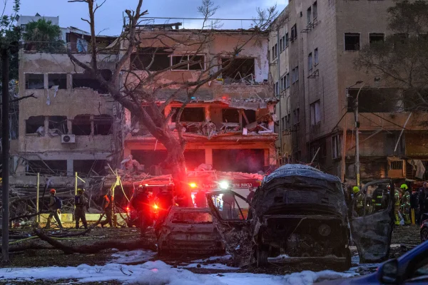 Equipes de resgate e segurança israelenses inspecionam e limpam os prédios e a área atingida por um foguete iraniano no centro de Tel Aviv, Israel