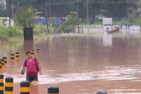 Imagem colorida de rua completamente alagada em Caieiras, com água suja da chuva - Metrópoles