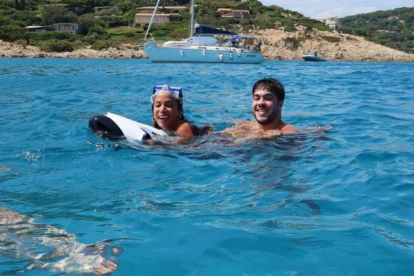 Na imagem colorida, Anitta e Alvaro aparecem nadando em mar europeu, brincando com moto aquática - Metrópoles