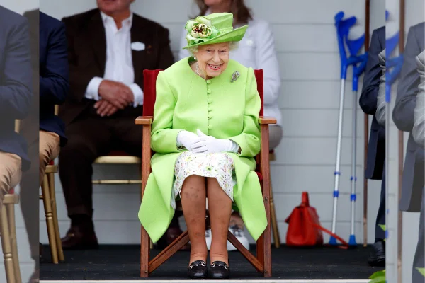 Foto colorida. Mulher idosa com roupa verde. Ela está sentada em uma cadeira