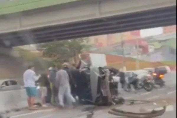 Carro capotado com pessoas ao redor - Metrópoles