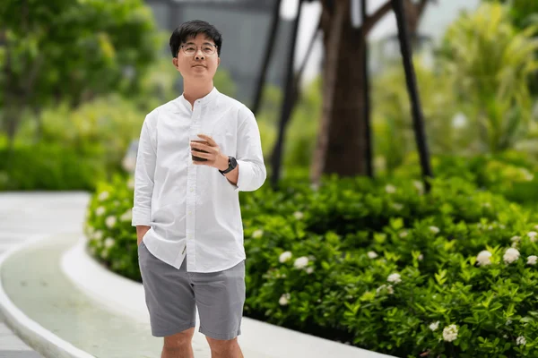 foto com cor. homem asiático usa bermuda em ambiente de trabalho - metrópoles