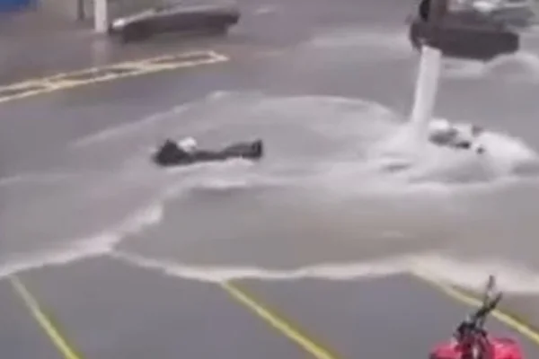 Imagem colorida mostra motociclista que caiu da moto e foi arrastado por uma correnteza durante as chuvas desse sábado (2) no Jardim Aricanduva, zona leste de SP - Metrópoles