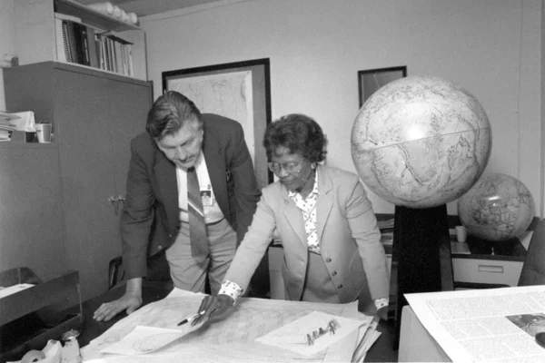Foto em preto e branco de Gladys West e Sam Smith olhando mapa - Metrópoles
