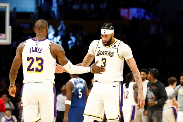 Foto colorida de LeBron James e Anthony Davis em jogo contra o Minnesota Timberwolves pela temporada 2023-24 da NBA
