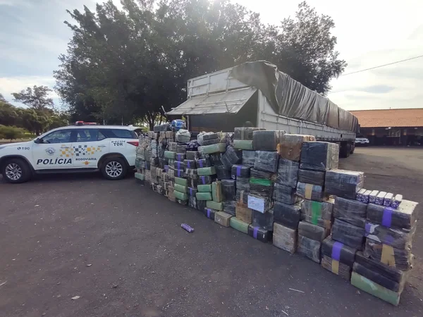 Imagem colorida mostra carro da polícia ao lado de mais uma tonelada de maconha apreendida em caminhão em rodovia de São Paulo - Metrópoles