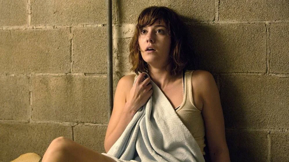 <b>Rua Cloverfield, 10: 24 de agosto</b>. Uma jovem (Mary Elizabeth Winstead) sofre um grave acidente de carro e acorda no porão de um desconhecido. O homem (John Goodman) diz ter salvado sua vida de um ataque químico que deixou o mundo inabitável, motivo pelo qual eles devem permanecer protegidos no local. Desconfiada da história, ela tenta descobrir um modo de se libertar <b>Rua Cloverfield, 10: 24 de agosto</b>. Uma jovem (Mary Elizabeth Winstead) sofre um grave acidente de carro e acorda no porão de um desconhecido. O homem (John Goodman) diz ter salvado sua vida de um ataque químico que deixou o mundo inabitável, motivo pelo qual eles devem permanecer protegidos no local. Desconfiada da história, ela tenta descobrir um modo de se libertar