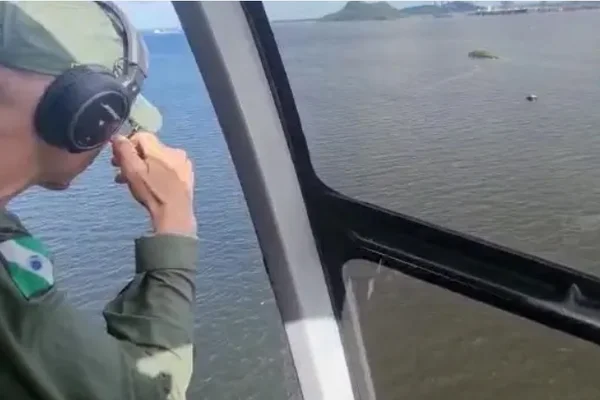 Imagem colorida: bombeiro em helicóptero faz buscas - Metrópoles