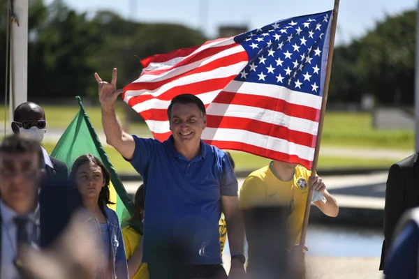 Bolsonaro na frente de bandeira dos Estados Unidos