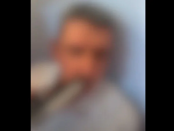 Imagem colorida e com blur mostra empresário com arma apontada para a boca