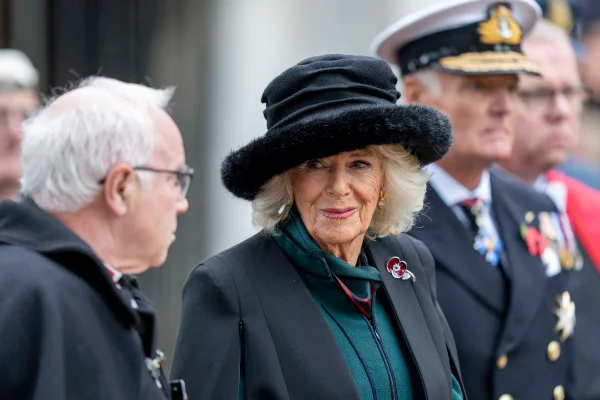 Rainha Camilla, uma mulher de cabelos brancos, idosa, está usando uma roupa e chapéu preto - Metrópoles