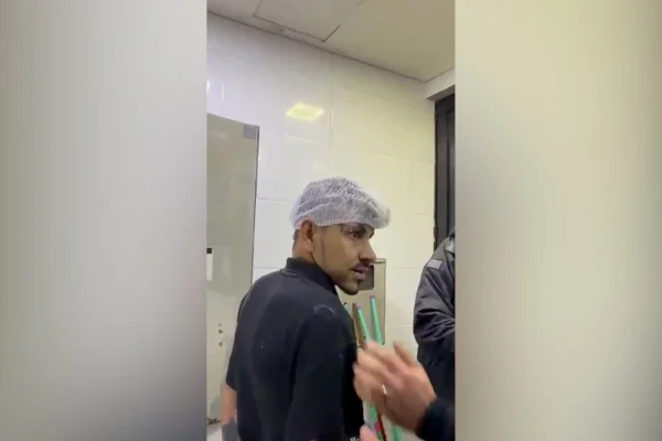 Foto de reprodução de vídeo do momento em que suspeito de estuprar e matar vizinha é preso cozinhando em restaurante.