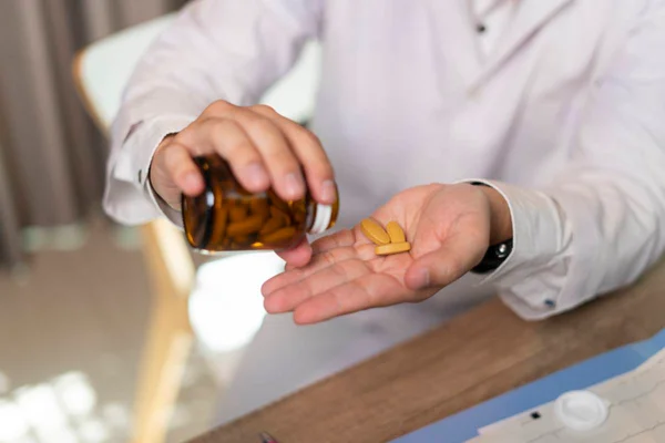 Imagem colorida de pessoa colocando multivitamínico nas mãos - MEtrópoles
