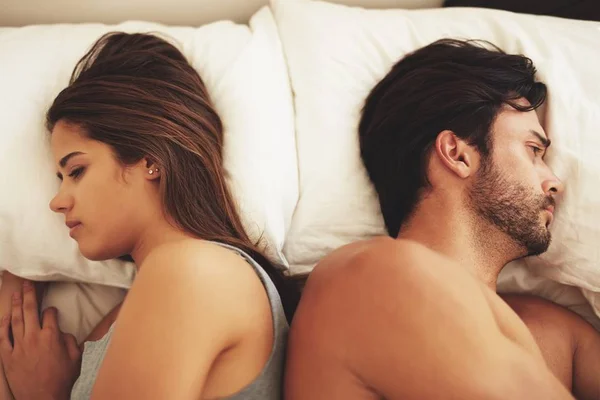 Casal deitado de costas um para o outro