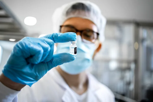 Foto de estoque de Farmacêutico ou tecnólogo em equipamentos de proteção que controlam a qualidade da produção de vacinas na fábrica. sarampo