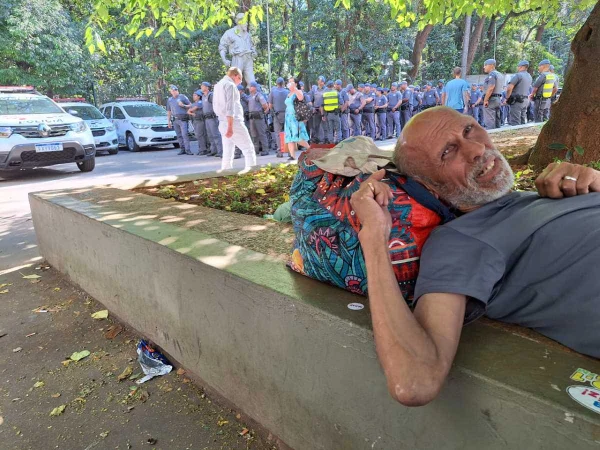 foto colorida de artista de rua deitado em sombra da Avenida Paulista, em tarde de sol forte em SP -Metrópoles