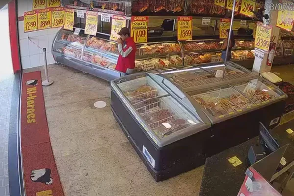 Homem de jaqueta vermelha em açougue - Metrópoles
