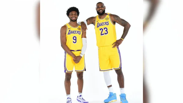 Foto colorida de LeBron James ao lado de seu filho, Bronny. Eles são companheiros de equipe no Los Angeles Lakers, da NBA - Metrópoles