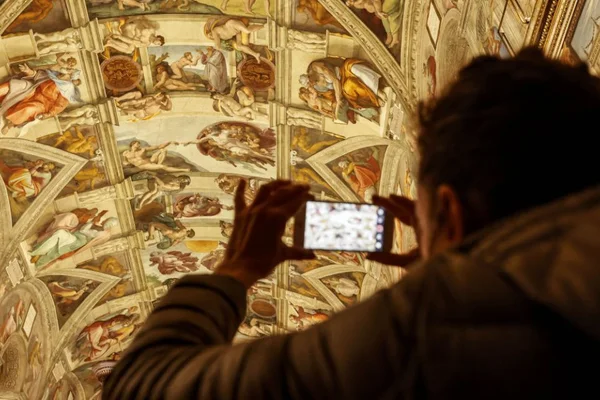homem fotografando teto da Capela Sistina