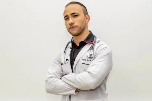 Jovem branco com jaleco de médico