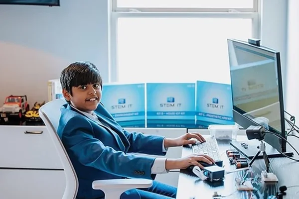 Imagem mostra o adolescente Siddarth Nandyala, que é indiano, de terno azul sentado na frente de um computador - Metrópoles
