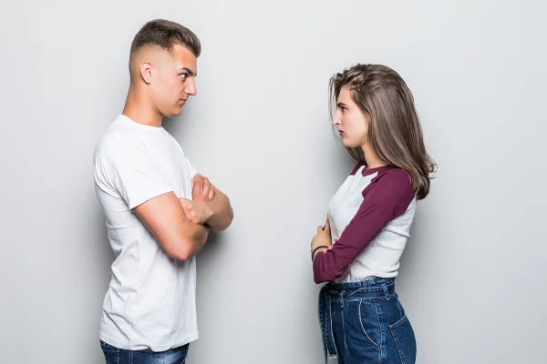 Foto colorida de dois adolescentes estressados se encarando - Metrópoles.