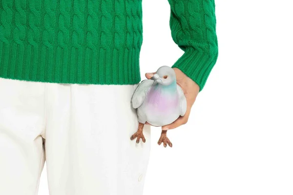 Na imagem com cor, homem segura bolsa de pombo da JW Anderson
