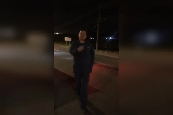 homem com uniforme gesticula para câmera