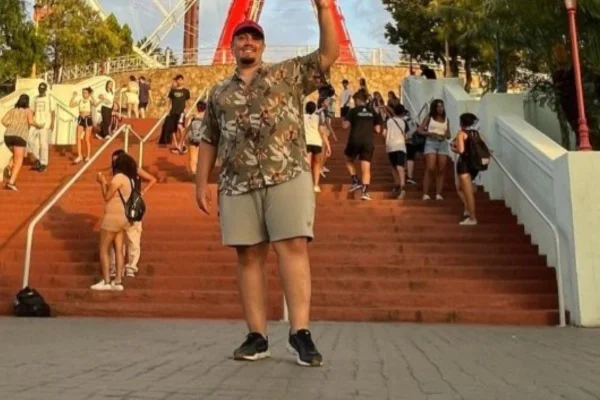 Homem em frente a uma roda gigante