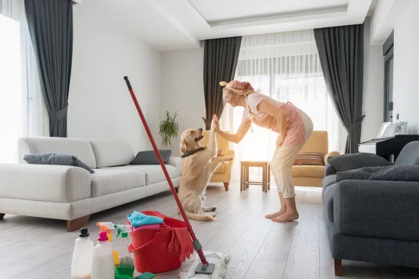 foto colorida mulher fazendo a limpeza de casa com seu pet