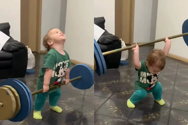 Foto colorida de um bebê levantando peso - Metrópoles
