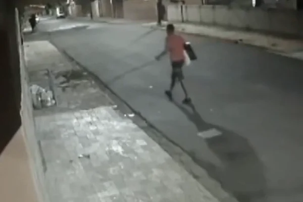 Imagem colorida de suspeito fugindo com televisor furtado de unidade de saúde no qual ele espalhou fezes durante o crime - Metrópoles