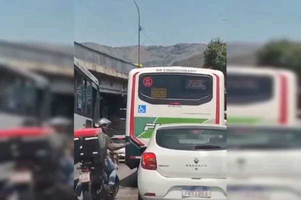 Motocilista ao lado de um carro branco