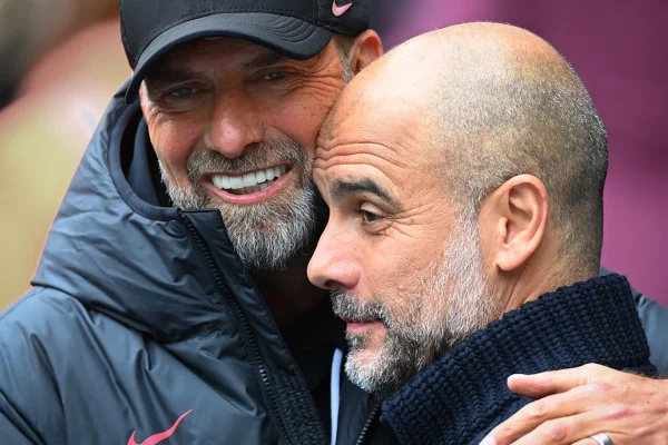 Imagem colorida de Klopp e Guardiola abraçados - Metrópoles